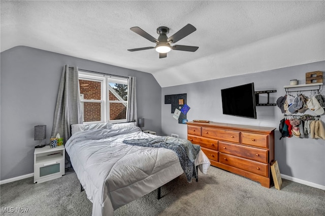 carpeted bedroom featuring lofted ceiling, ceiling fan, a textured ceiling, and baseboards