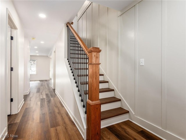 staircase with baseboards, wood finished floors, and recessed lighting