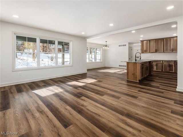 unfurnished living room featuring baseboards, visible vents, dark wood-style flooring, and recessed lighting