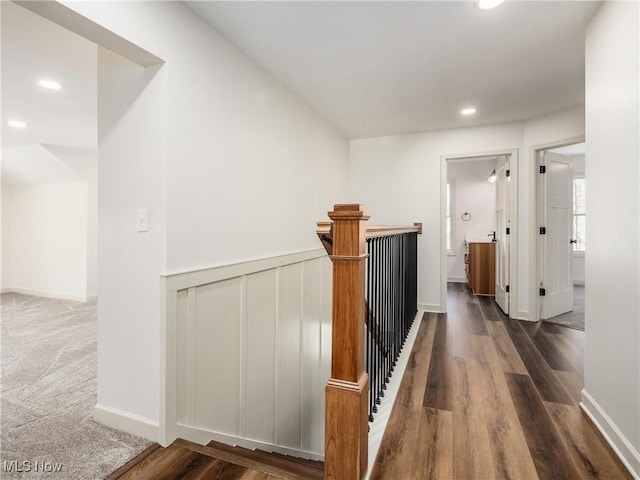 hall with dark wood-style floors, baseboards, an upstairs landing, and recessed lighting