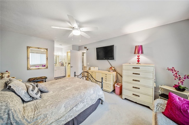 bedroom featuring light carpet, ceiling fan, and connected bathroom