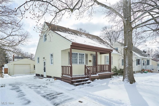 bungalow featuring a garage and an outbuilding