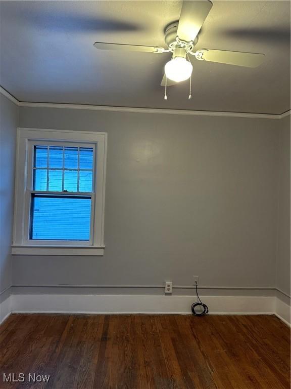 empty room with dark wood-type flooring, baseboards, and a ceiling fan