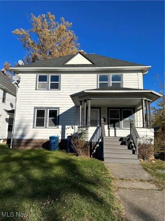 view of front of home with a front lawn, a porch, and roof with shingles