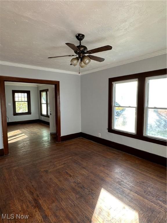 spare room featuring ceiling fan, baseboards, a textured ceiling, and ornamental molding