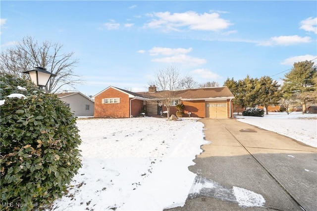 single story home with a garage, driveway, and brick siding