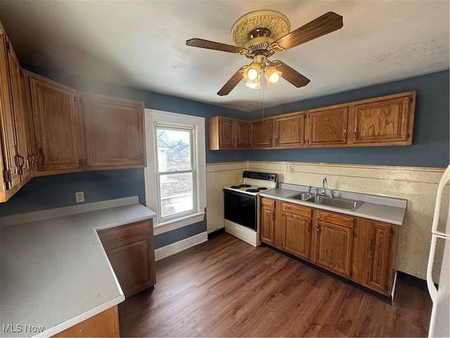 kitchen featuring light countertops, a sink, and electric range