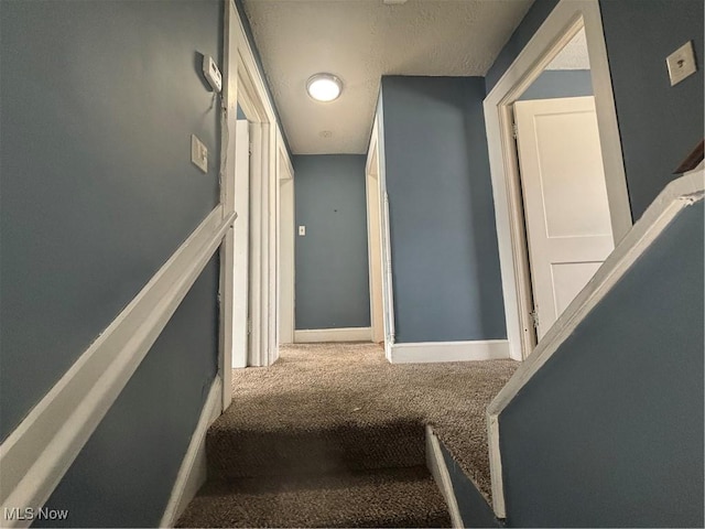 stairway featuring carpet and baseboards