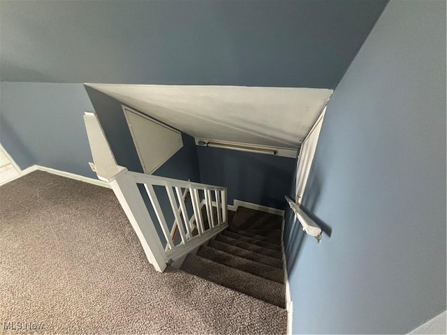 staircase with lofted ceiling, baseboards, and carpet flooring