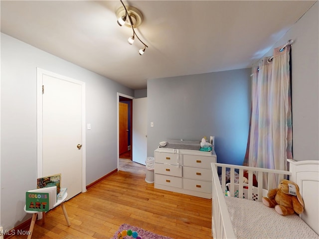 bedroom with light wood-style flooring and baseboards