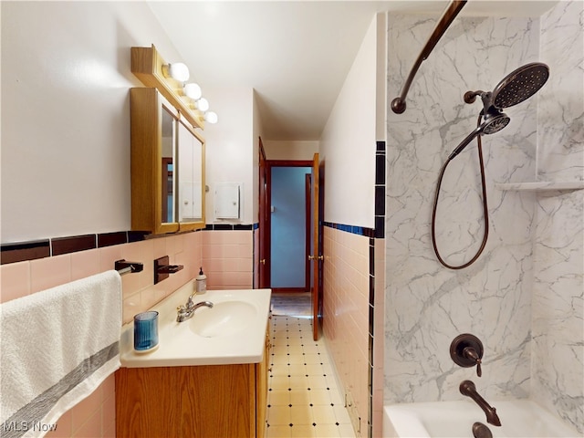 bathroom featuring a wainscoted wall, shower / washtub combination, tile walls, and vanity