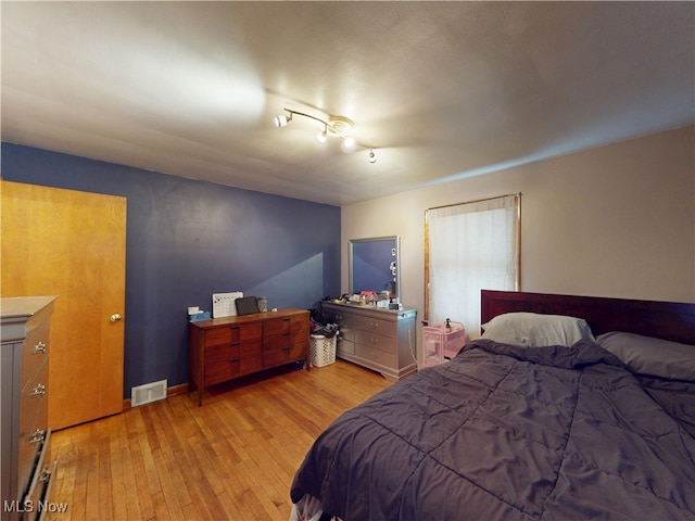 bedroom with light wood-type flooring, baseboards, and visible vents