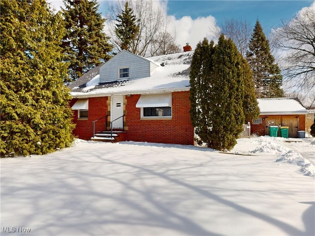 view of front of house with brick siding and a chimney