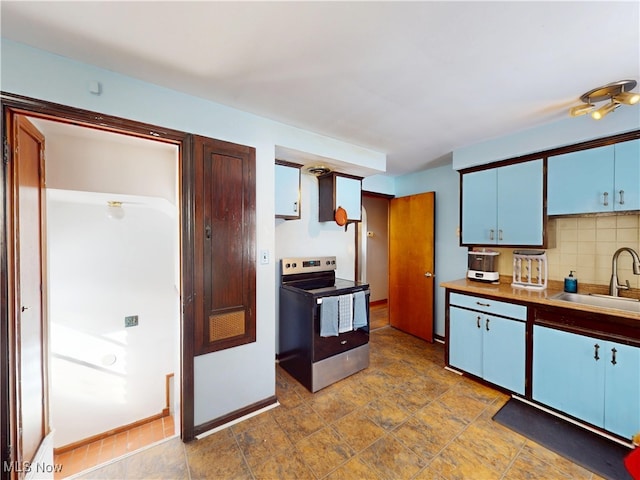 kitchen featuring baseboards, decorative backsplash, stainless steel range with electric stovetop, blue cabinetry, and a sink