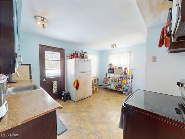 kitchen with a wealth of natural light, freestanding refrigerator, a sink, and range with electric stovetop