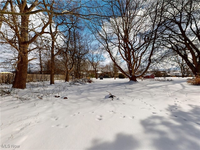 yard layered in snow with fence