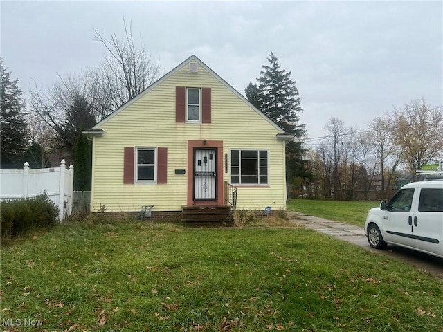 bungalow-style house with fence and a front lawn