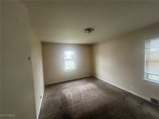 unfurnished room featuring a wealth of natural light and visible vents