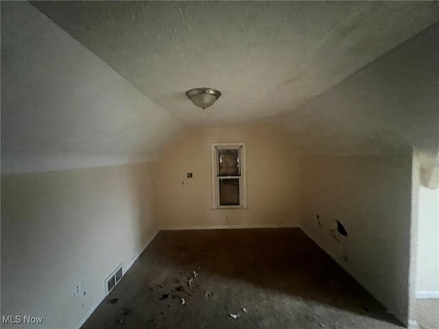 bonus room with vaulted ceiling and visible vents