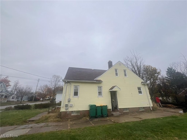 back of property with a yard and a chimney