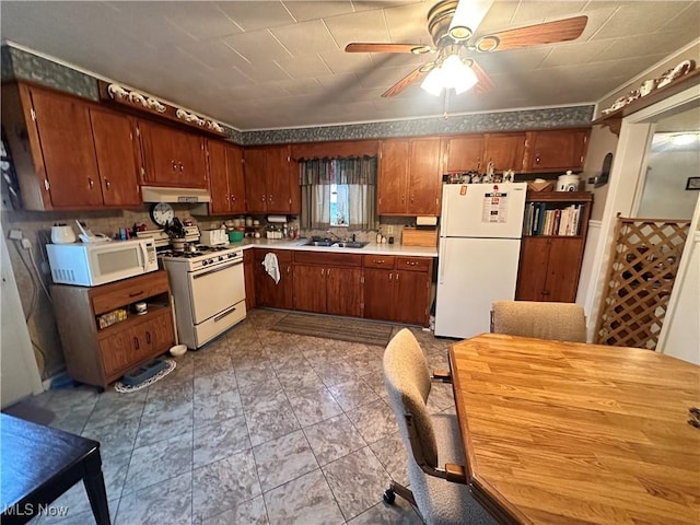 kitchen featuring white appliances, brown cabinetry, light countertops, under cabinet range hood, and a sink