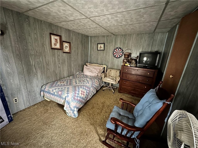 bedroom featuring carpet and wooden walls