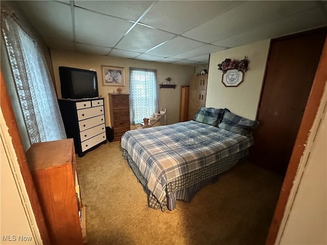 carpeted bedroom with a drop ceiling