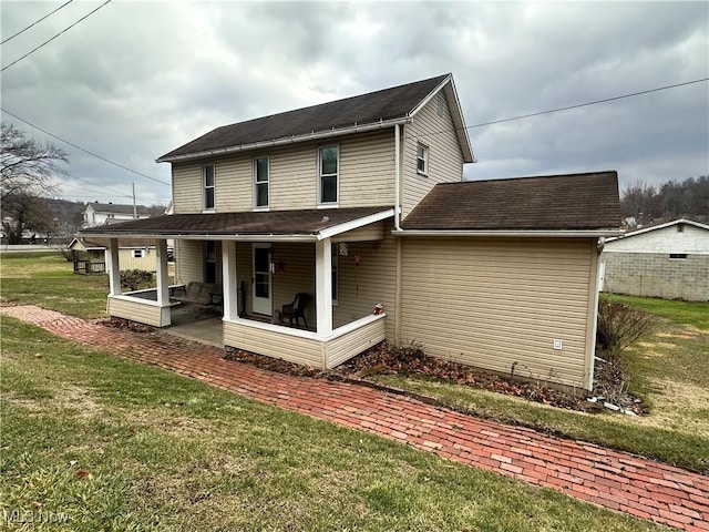 back of property with a patio area and a yard