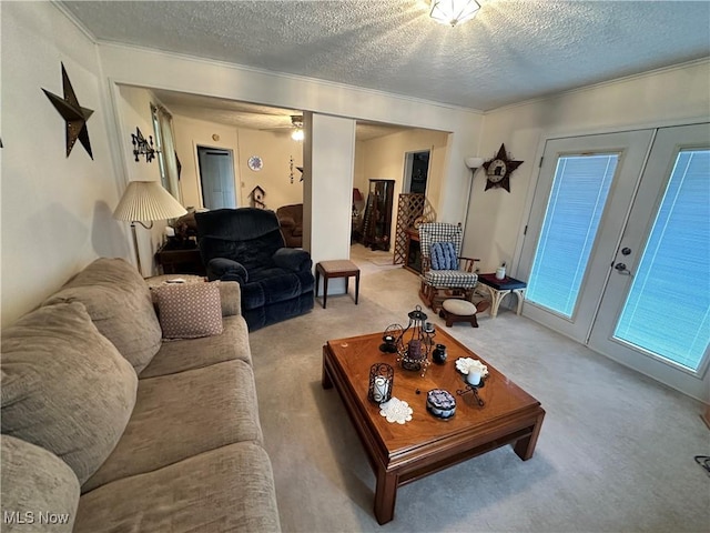 carpeted living area with a textured ceiling and french doors