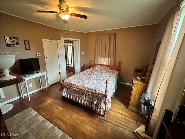 bedroom with a ceiling fan, dark wood finished floors, baseboards, and ornamental molding