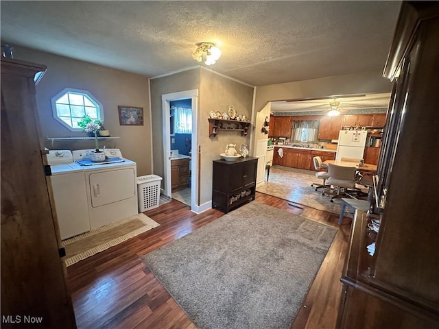 washroom with laundry area, washer and clothes dryer, dark wood-style flooring, and a textured ceiling