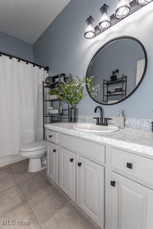 full bathroom with toilet, tile patterned flooring, and vanity