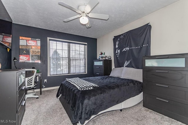 bedroom featuring a ceiling fan, light carpet, a textured ceiling, and baseboards