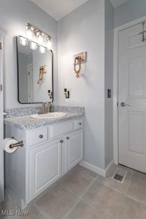 bathroom featuring tile patterned floors, baseboards, visible vents, and vanity