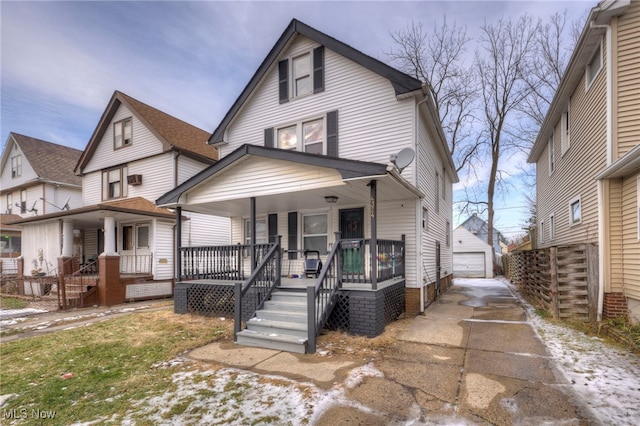 traditional style home featuring a garage, covered porch, and an outdoor structure