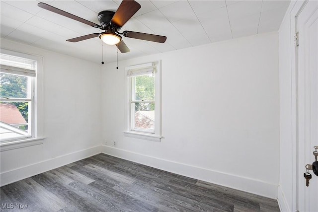 empty room featuring dark wood-style floors, ceiling fan, and baseboards