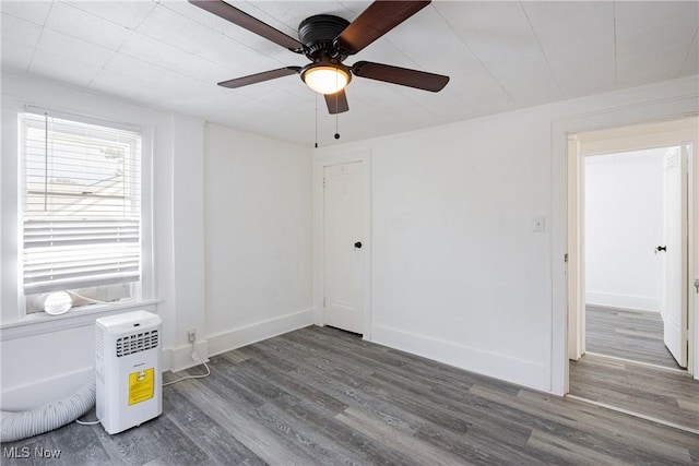 spare room with a ceiling fan, baseboards, and wood finished floors