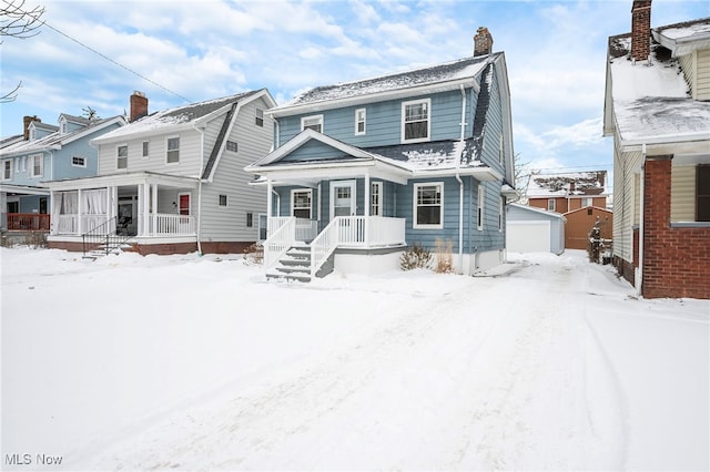 snow covered house featuring a garage, an outdoor structure, and a chimney