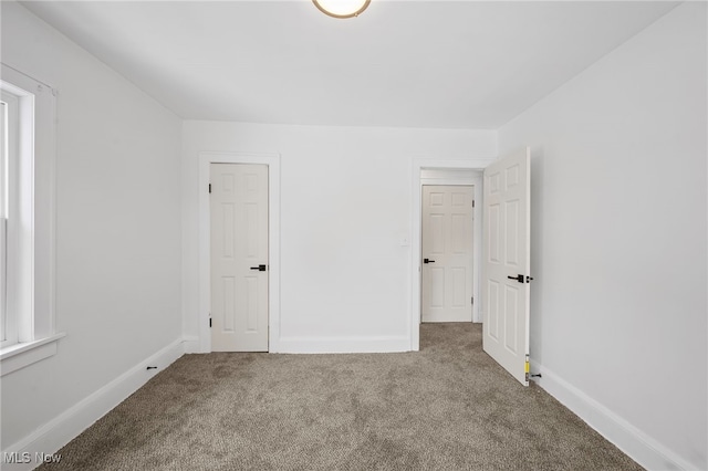 unfurnished bedroom featuring carpet flooring and baseboards