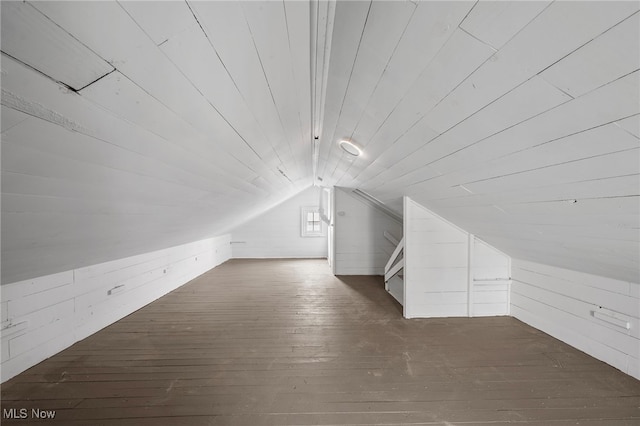 additional living space with lofted ceiling, wood walls, wood ceiling, and dark wood-style floors