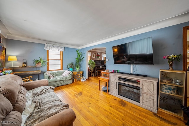 living room with arched walkways and wood finished floors