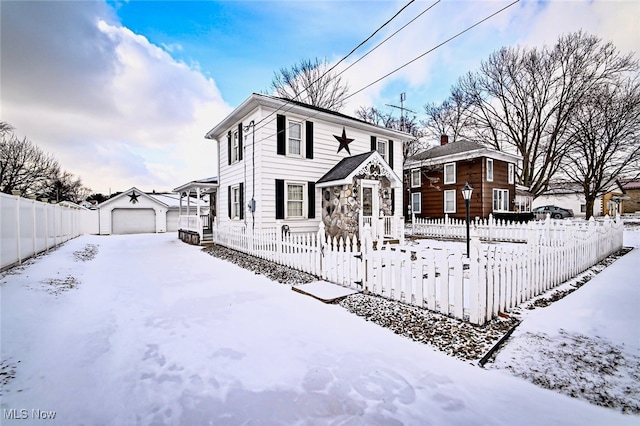 view of front of house with a garage, an outdoor structure, and a fenced front yard