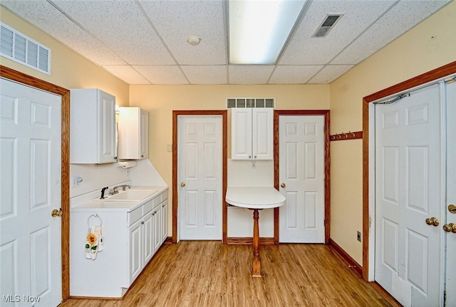 washroom featuring light wood-style floors, a sink, and visible vents