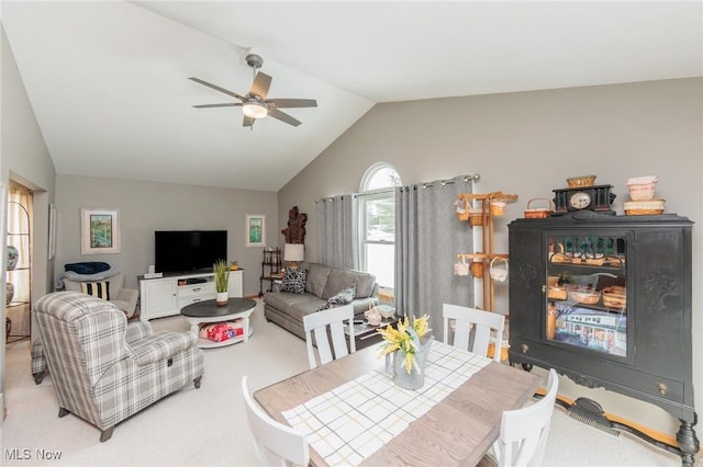 carpeted dining area with a ceiling fan and lofted ceiling