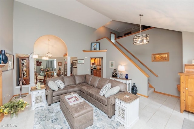 living room with stairs, high vaulted ceiling, baseboards, and a notable chandelier