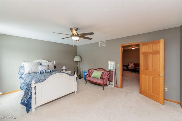 bedroom featuring a ceiling fan, visible vents, light carpet, and baseboards