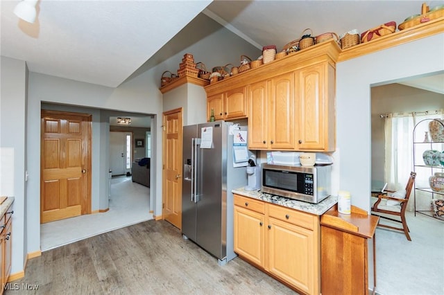 kitchen with stainless steel appliances, light wood finished floors, light countertops, and baseboards