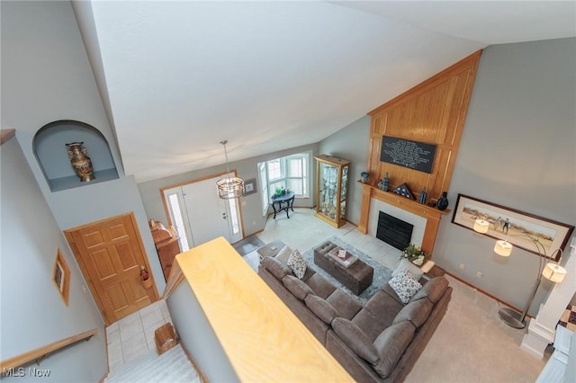 living room with lofted ceiling, a large fireplace, and baseboards