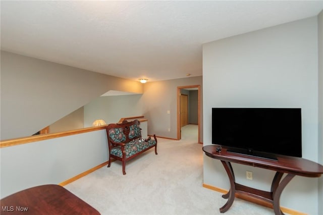 living area with light carpet and baseboards