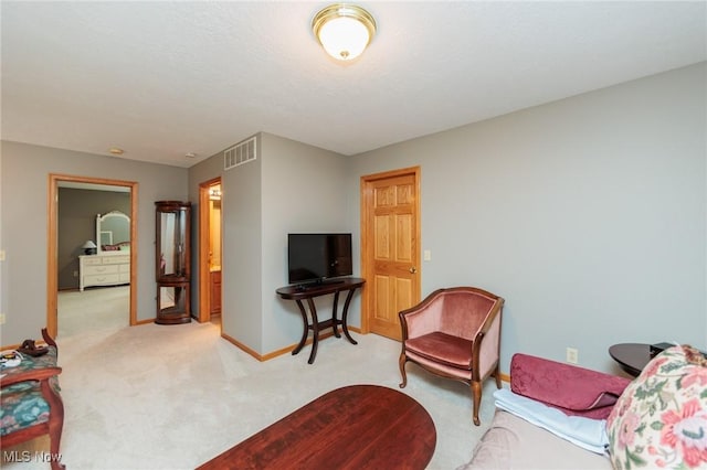 living area featuring light carpet, baseboards, and visible vents